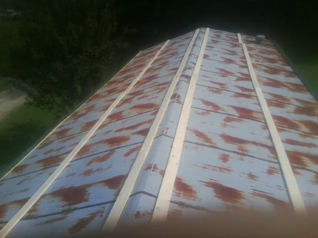 Rusted metal roof panels with new wood purlins before replacement — Storm Damage Roof Repair in Flora by Roofing Brothers