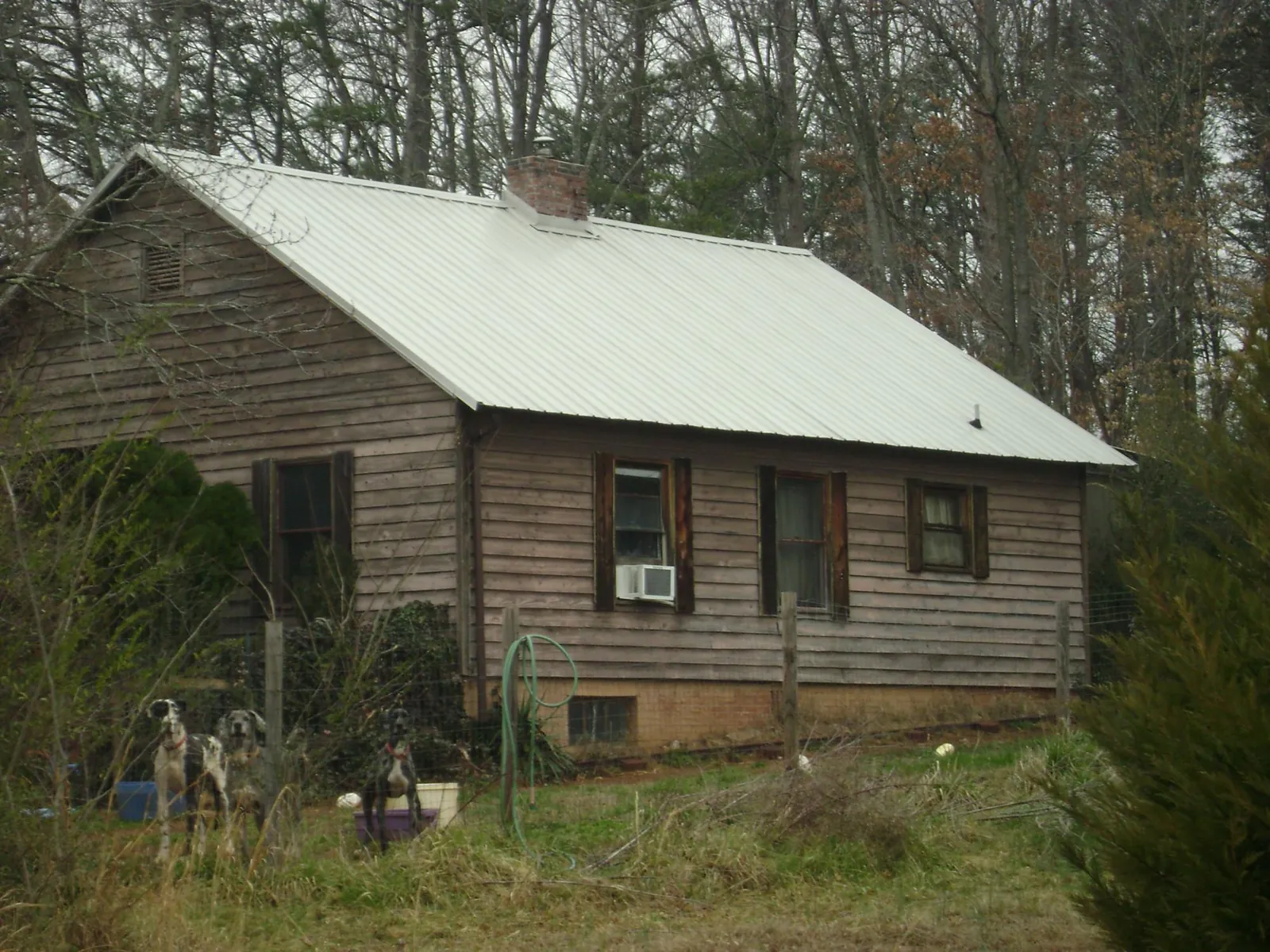 White metal roof on an old wood sided farmhouse, from a Metal Roof Installation job in Flora
